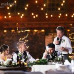 Wedding party seated on verande at night.